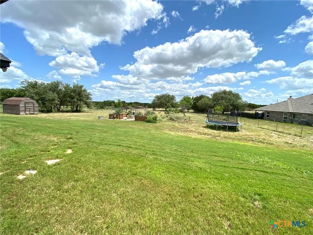 view of yard featuring a rural view and a trampoline