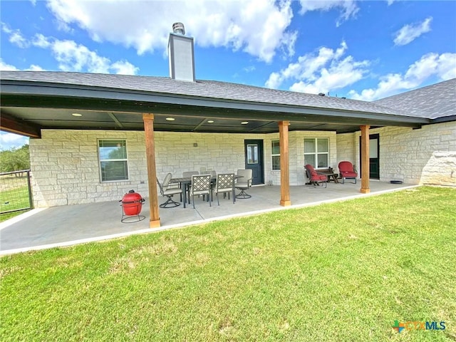 rear view of house featuring a yard and a patio