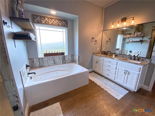 bathroom with wood-type flooring, vanity, and a tub to relax in