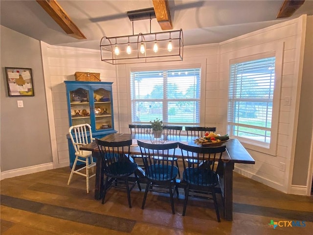 dining space with beam ceiling and dark hardwood / wood-style flooring