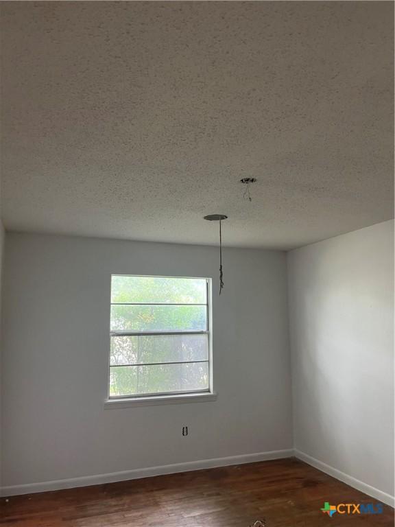 2110 Terrace Dr, Copperas Cove, TX 76522 - spare room featuring baseboards, a textured ceiling, and wood finished floors