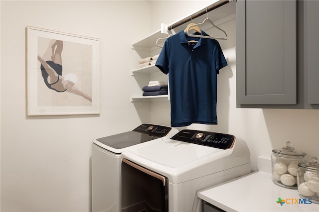 laundry area with washing machine and clothes dryer and cabinets