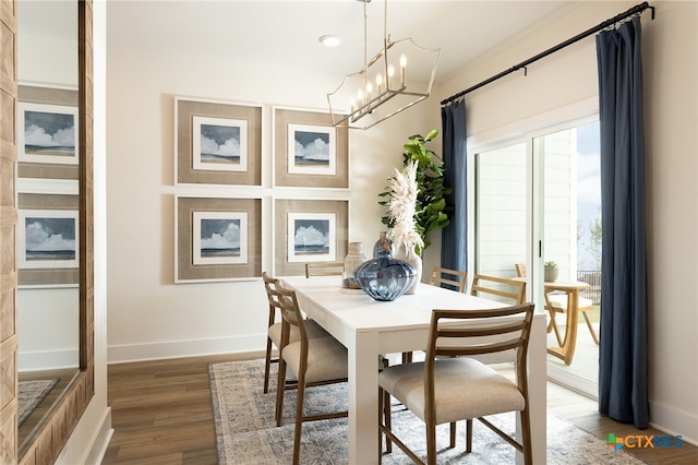 dining area with dark hardwood / wood-style flooring and a notable chandelier