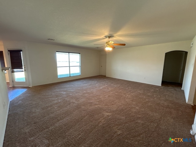 empty room featuring dark colored carpet and ceiling fan