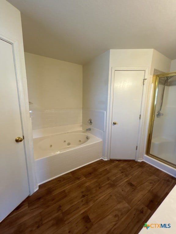 bathroom with plus walk in shower and hardwood / wood-style flooring