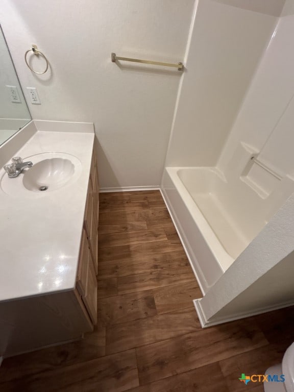 bathroom with hardwood / wood-style floors, vanity, and toilet