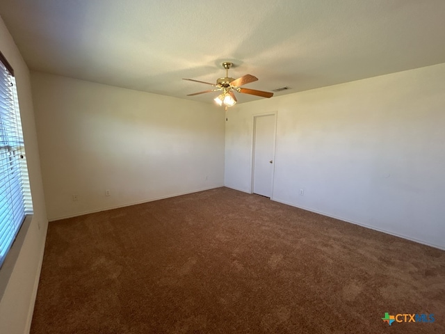 carpeted empty room with ceiling fan and plenty of natural light