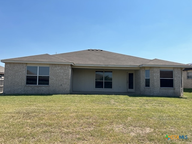 rear view of property with a yard