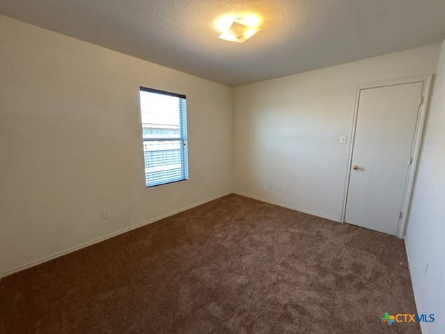 carpeted spare room featuring a textured ceiling