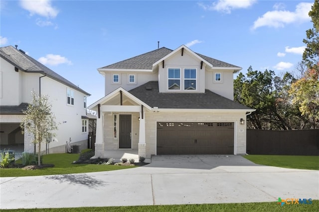 view of front of home featuring a front yard, a garage, and central air condition unit