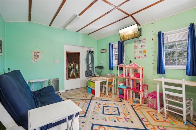 recreation room with wood-type flooring and radiator