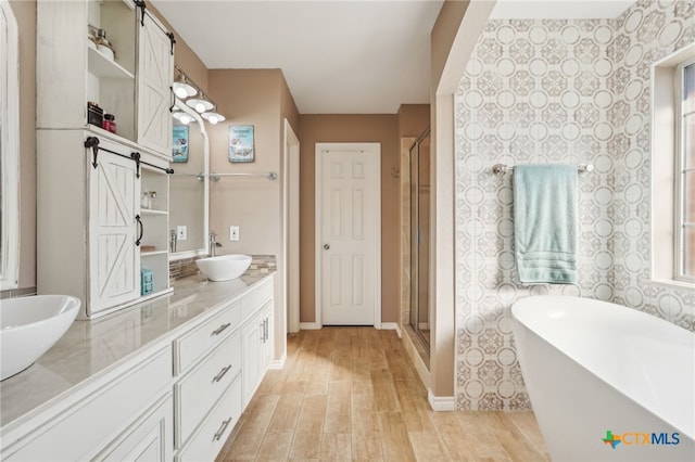 bathroom with vanity, hardwood / wood-style floors, and plus walk in shower