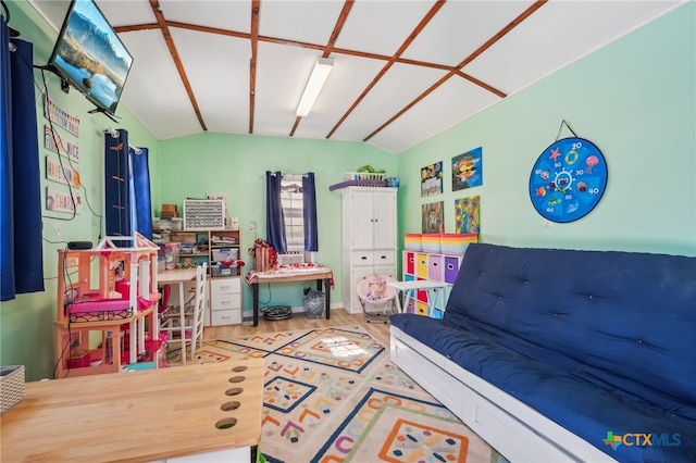 recreation room featuring wood-type flooring and lofted ceiling