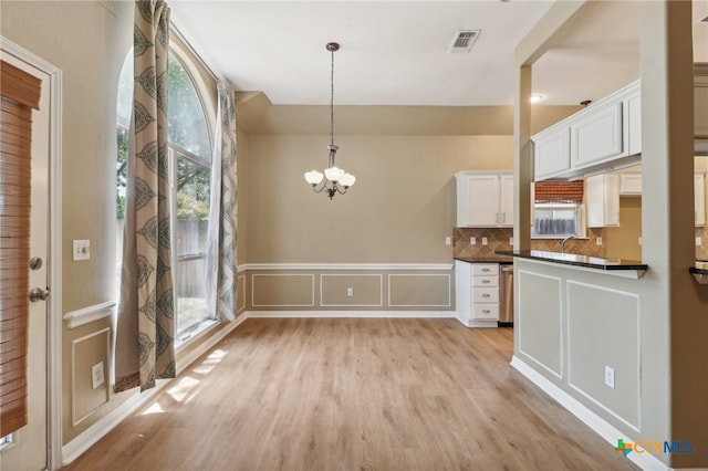 kitchen with an inviting chandelier, white cabinets, decorative backsplash, light hardwood / wood-style flooring, and decorative light fixtures