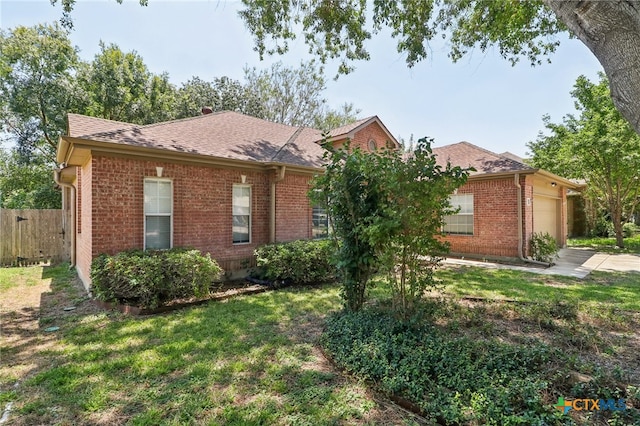 ranch-style house featuring a garage and a front lawn