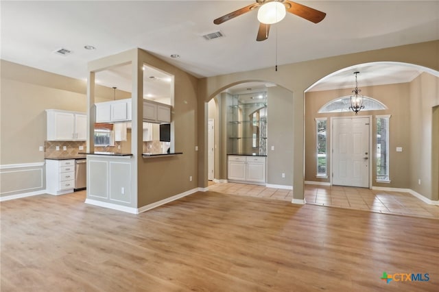 foyer featuring light wood-type flooring and ceiling fan with notable chandelier