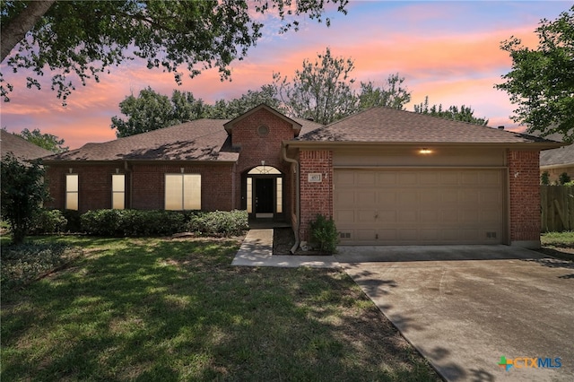 single story home featuring a lawn and a garage