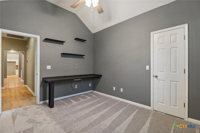 interior space featuring light carpet, ceiling fan, and vaulted ceiling