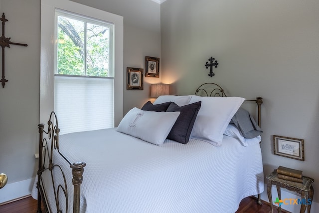 bedroom with dark hardwood / wood-style flooring