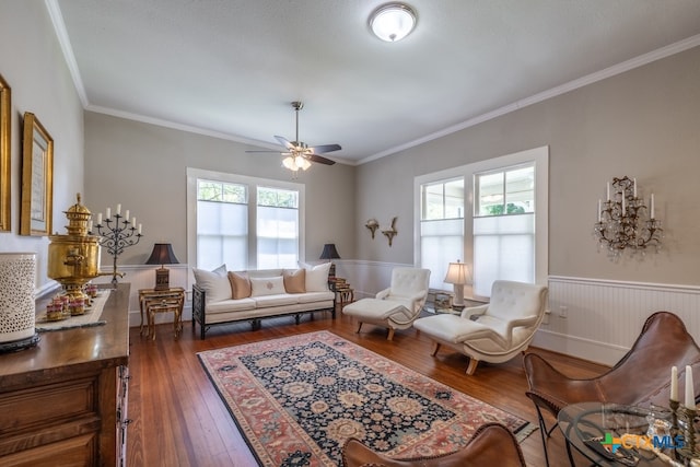 sitting room with dark wood-type flooring, ceiling fan, a healthy amount of sunlight, and crown molding