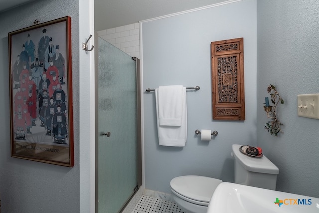 bathroom with toilet and a shower with shower door