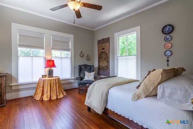 bedroom with dark hardwood / wood-style flooring, ornamental molding, multiple windows, and ceiling fan