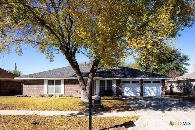 ranch-style home featuring a garage and a front lawn