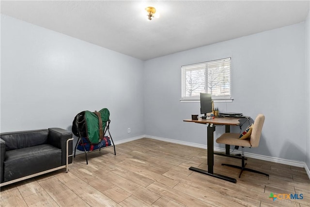 office featuring baseboards and light wood finished floors