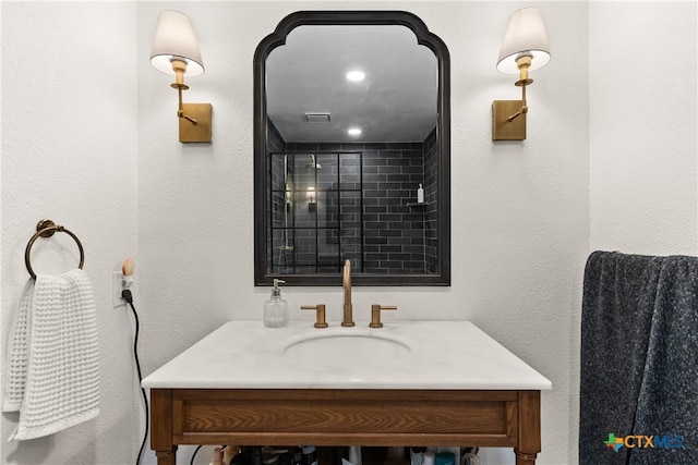 full bath featuring vanity, a shower stall, and visible vents