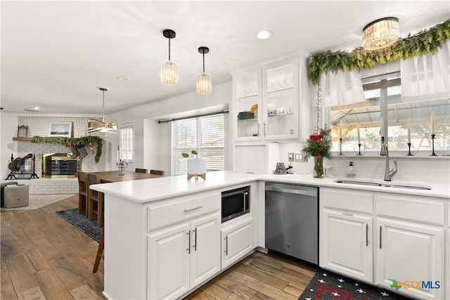 kitchen featuring kitchen peninsula, built in microwave, sink, dishwasher, and white cabinetry