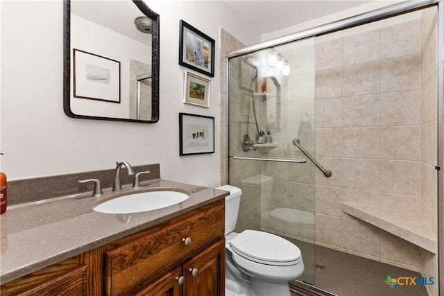 bathroom featuring toilet, a stall shower, and vanity