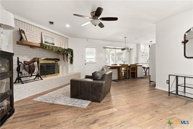 living room featuring ceiling fan and light hardwood / wood-style flooring