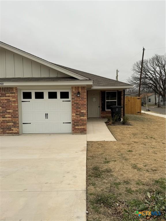 single story home with a front yard and a garage