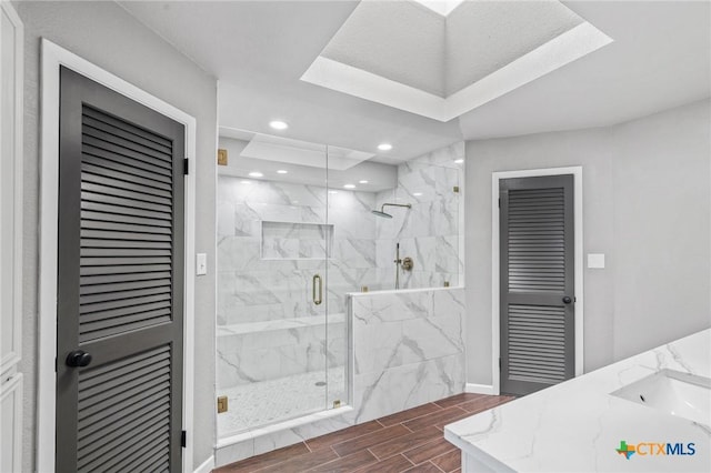 bathroom with a marble finish shower, a closet, baseboards, wood finish floors, and recessed lighting