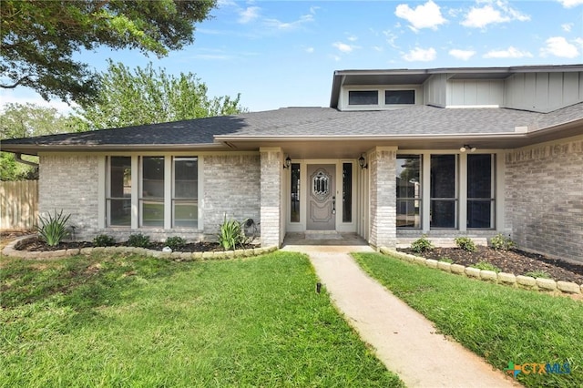 view of front of house featuring a front lawn and brick siding