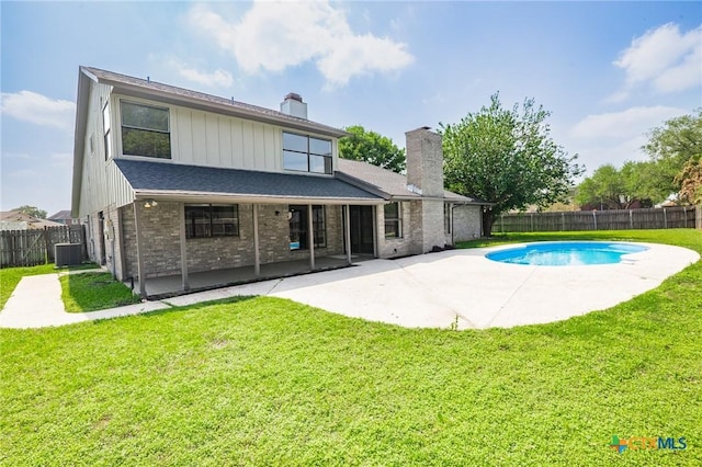 rear view of house with central AC, a chimney, a lawn, a fenced backyard, and a patio area