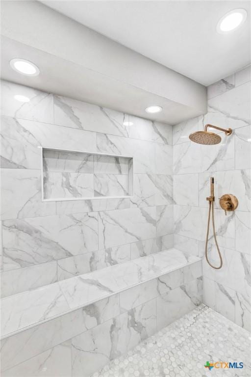 interior details with tiled shower and recessed lighting