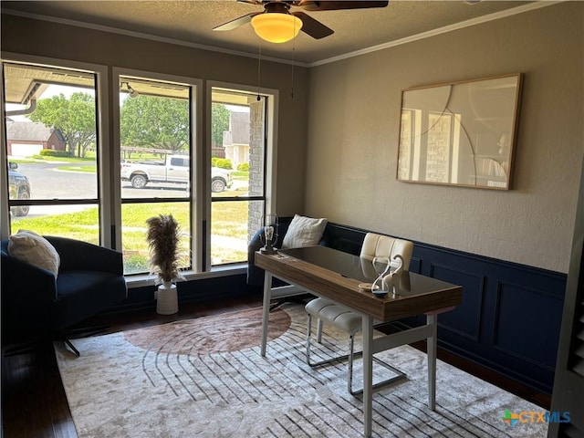 office space featuring ornamental molding, ceiling fan, a decorative wall, wood finished floors, and a textured wall