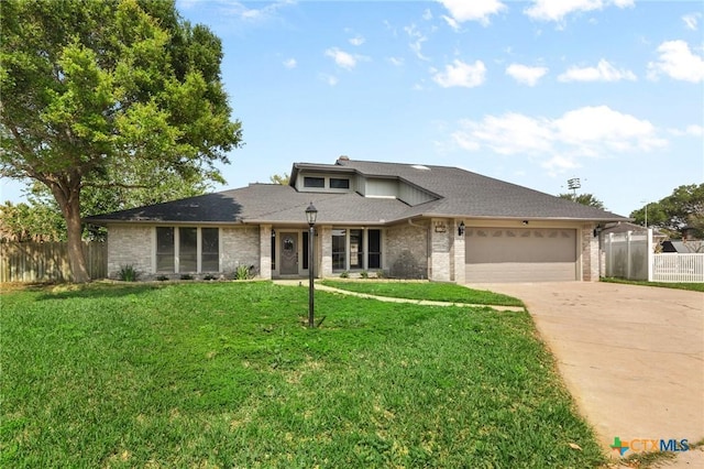 view of front of home featuring fence, an attached garage, brick siding, concrete driveway, and a front lawn