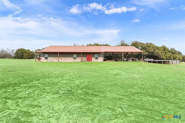 back of property featuring metal roof and an outdoor structure