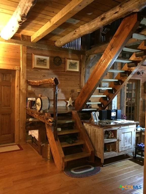 2911 Sulphur Wells Rd, Salado, TX 76571 - bar area with beamed ceiling, wooden walls, wood ceiling, wood finished floors, and stairs