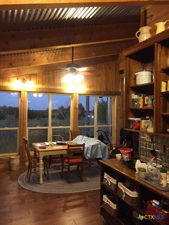 2911 Sulphur Wells Rd, Salado, TX 76571 - dining space with beamed ceiling, wood walls, dark wood finished floors, and ceiling fan