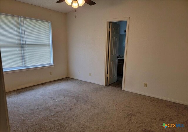 carpeted spare room featuring ceiling fan