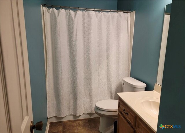 bathroom with vanity, walk in shower, tile patterned floors, and toilet