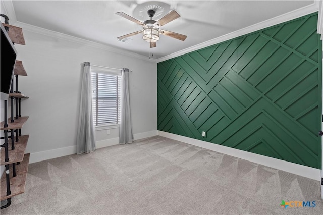 spare room with crown molding, carpet flooring, and ceiling fan