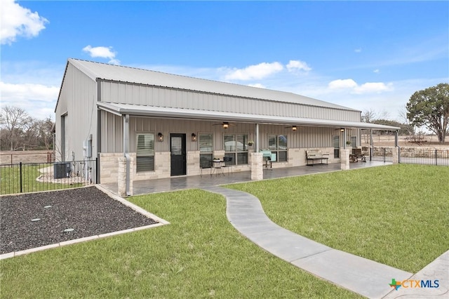 back of property featuring ceiling fan, a yard, and a patio area