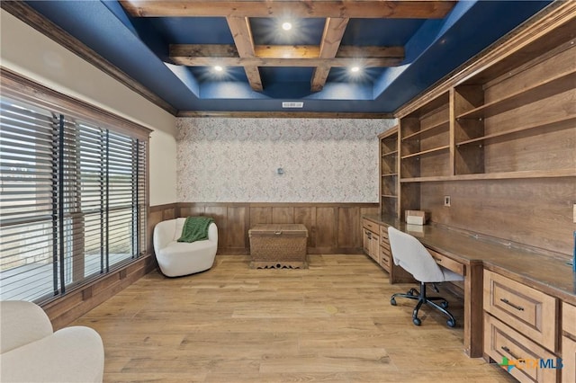 home office with beamed ceiling, coffered ceiling, built in desk, and light wood-type flooring