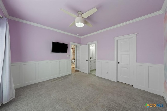 unfurnished bedroom with light carpet, crown molding, ceiling fan, and ensuite bathroom