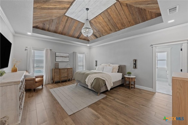 bedroom featuring hardwood / wood-style flooring, ornamental molding, and a tray ceiling