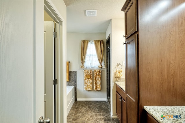 bathroom featuring a textured ceiling, vanity, and shower with separate bathtub